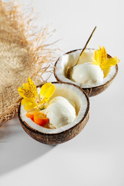 Straw hat and ice cream in half of coconut. Summer Vacation concept.