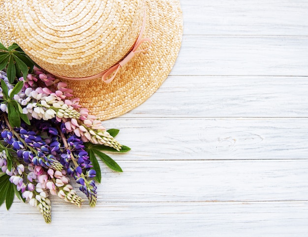 Straw hat and lupine flowers