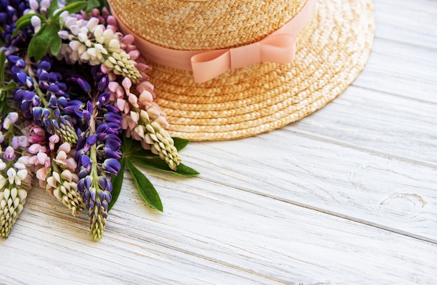 Straw hat and lupine flowers