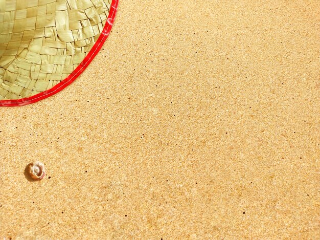 写真 デザインの背景として使用される空白スペースを持つ熱帯のビーチの砂の上の麦わら帽子