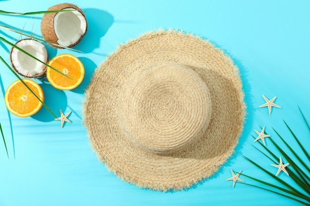 Straw hat, oranges, coconuts, palm leaves and starfishes on color background, space for text and top view. summer vacation concept