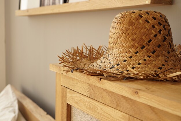 Straw hat on the shelf in room in a Scandinavian style