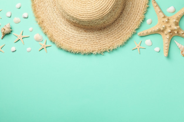 Straw hat and starfishes on mint, top view