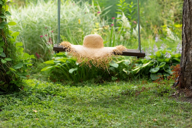 Straw hat on swing on natural green