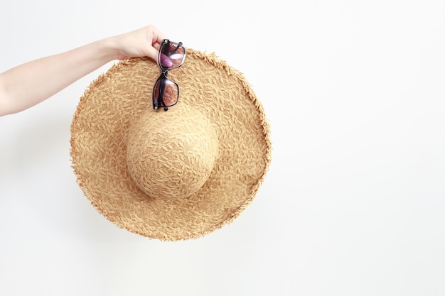 Straw hat for vacation and sunglasses on a white background