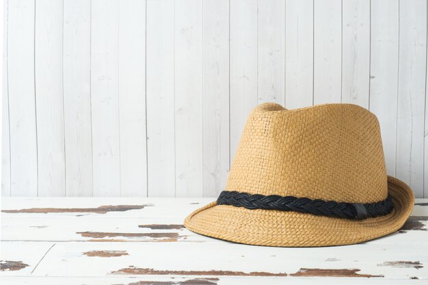 Straw hat on white boards with copy space.