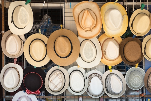 Photo straw hats for sale, hanging on a wall