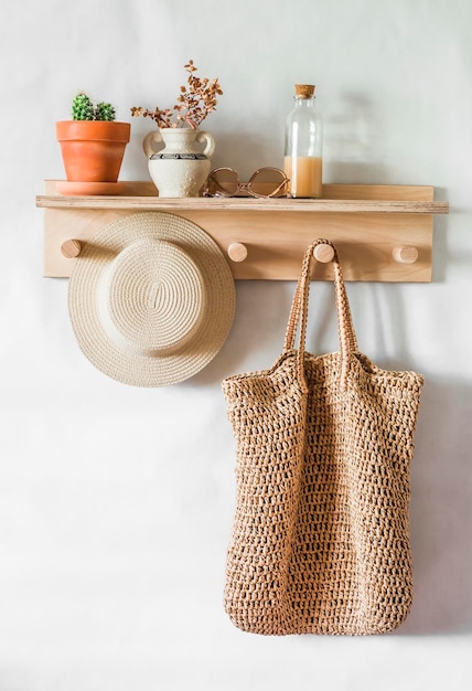 Straw shopping bag hat on a wooden shelf in the hallway Simple interior design