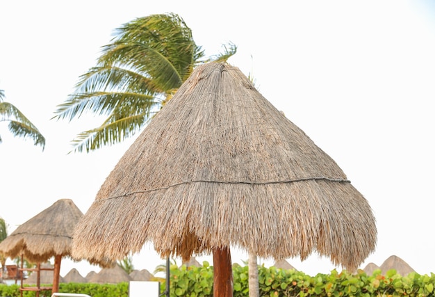 A straw umbrella that is made by the company of the beach club.