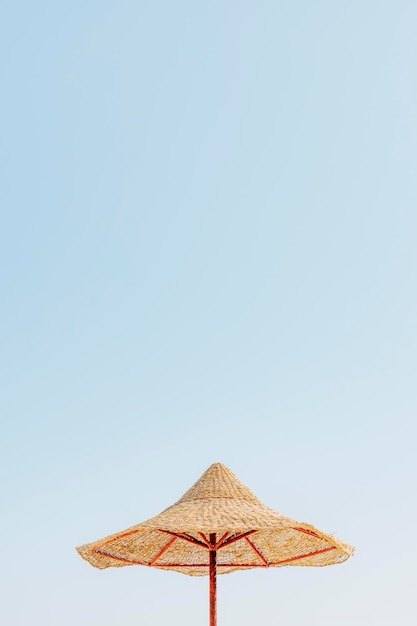 Ombrellone di paglia o capanna di paglia con splendida vista del cielo sulla spiaggia tropicale