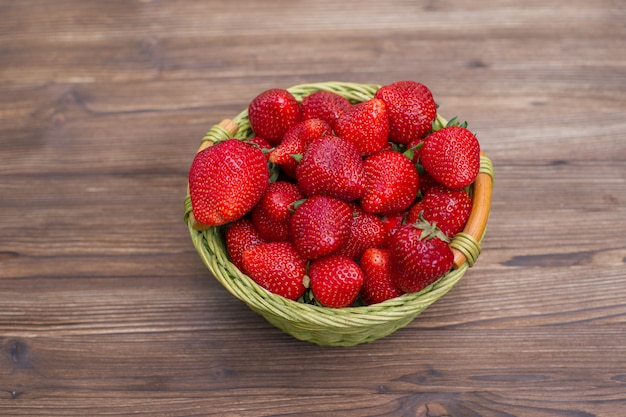 Strawberries in a basket on wood