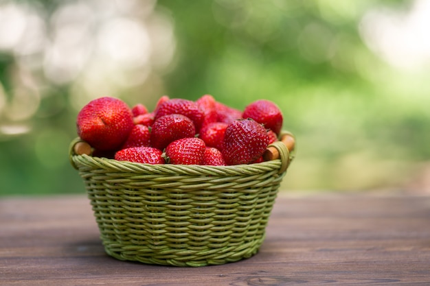 Strawberries in a basket on wood