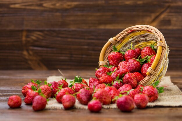 Strawberries in basket on wooden table