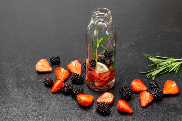 Strawberries and blackberries on the table A bottle of water with berries