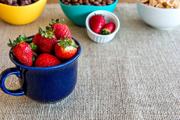 Strawberries in a blue cup, healthy breakfast.