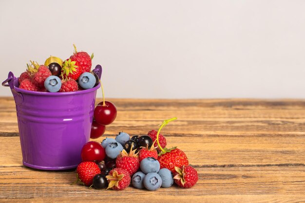 Foto fragole mirtilli ciliegie ceri nero e rosso ribes su un tavolo di legno su uno sfondo chiarox9