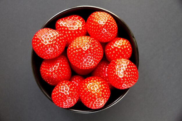 Strawberries in a bowl. Black background. Studio shooting