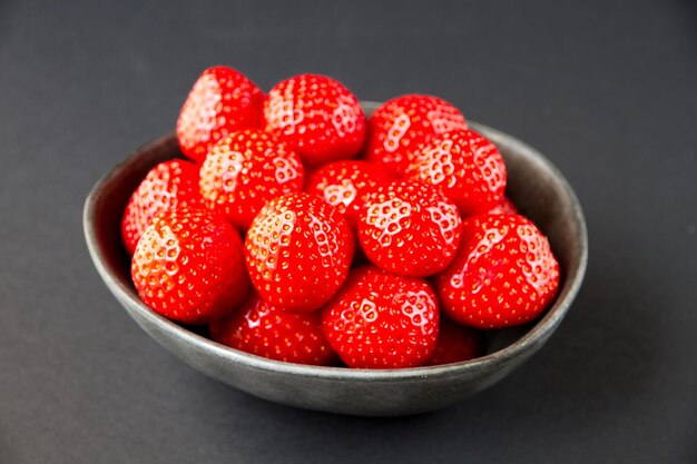 Strawberries in a bowl. Black background. Studio shooting