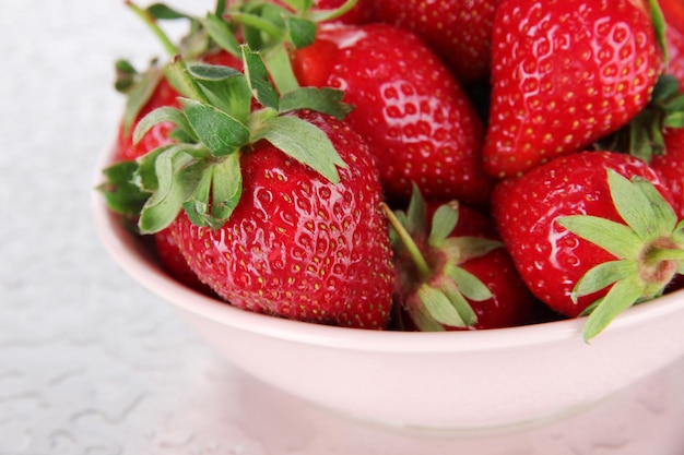 Strawberries in bowl on metal background