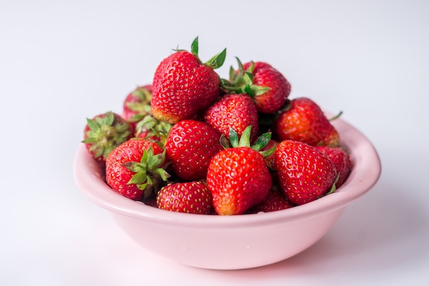 Strawberries in a bowl on a white space