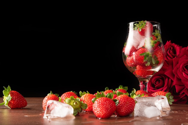 딸기, 딸기와 얼음 그릇과 테이블, 선택적 초점에 더 많은 딸기와 얼음 조각.