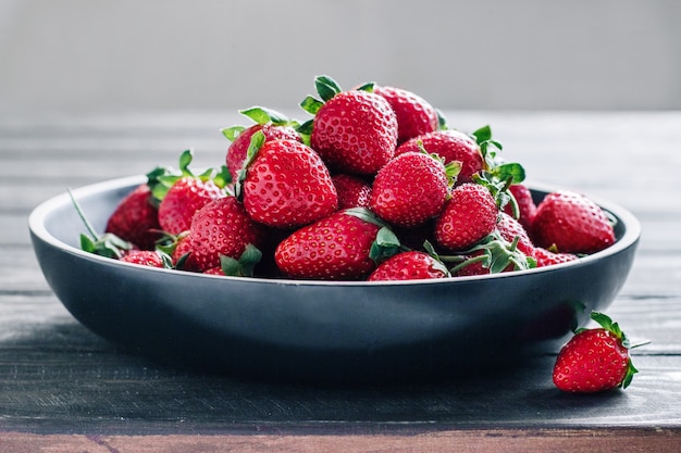 Strawberries in a bowl on a wooden table