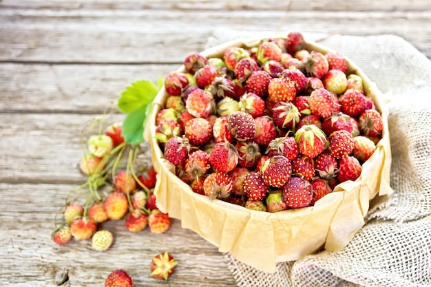 Photo strawberries in box on wooden board