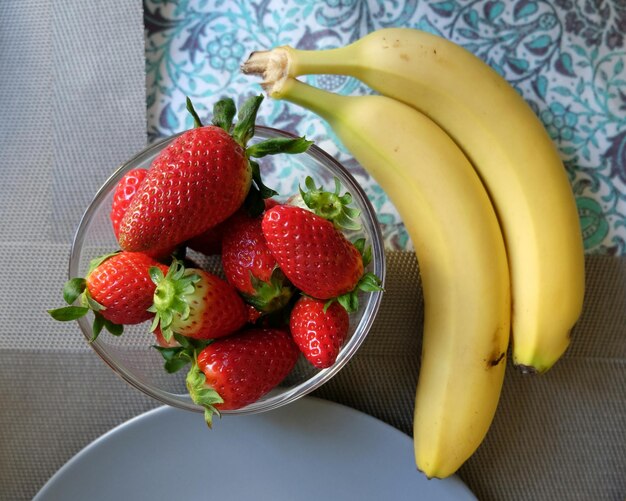 Photo strawberries by bananas in bowl