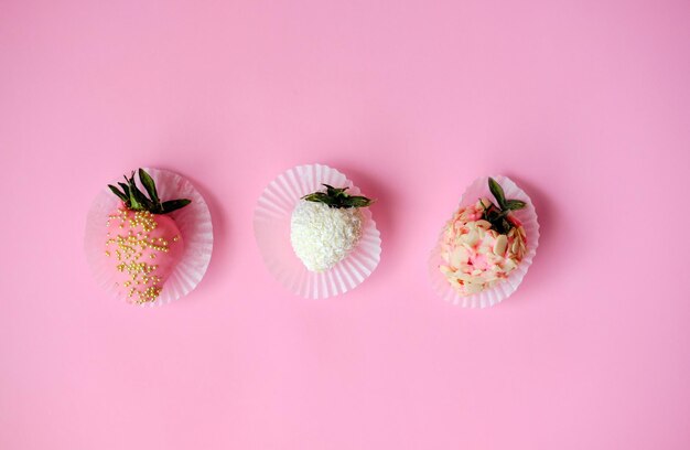 Strawberries in chocolate on a pink background Sweet snack with berries in chocolate