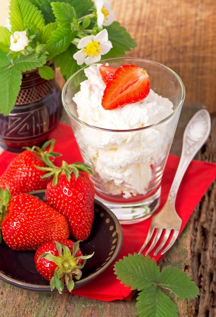 Strawberries and cottage cheese in a glass with leaves. Isolated on a white background.