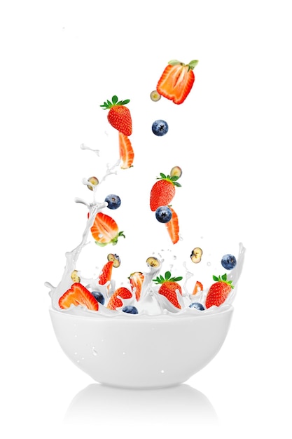 Strawberries falling into a fresh bowl of cream healthy breakfast milk and fresh berries