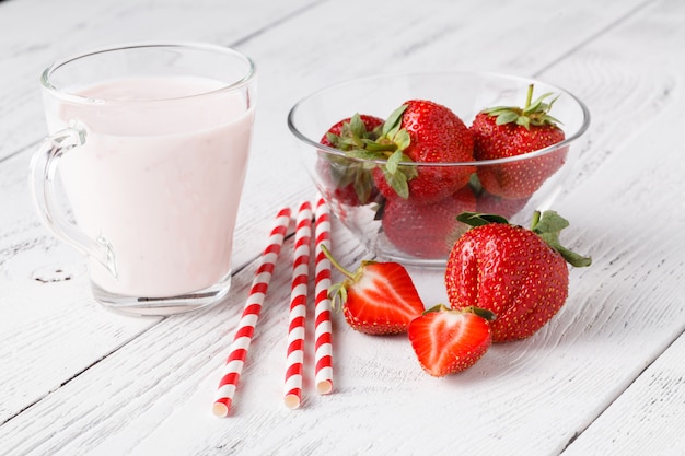 Strawberries and milk drink on white wooden table