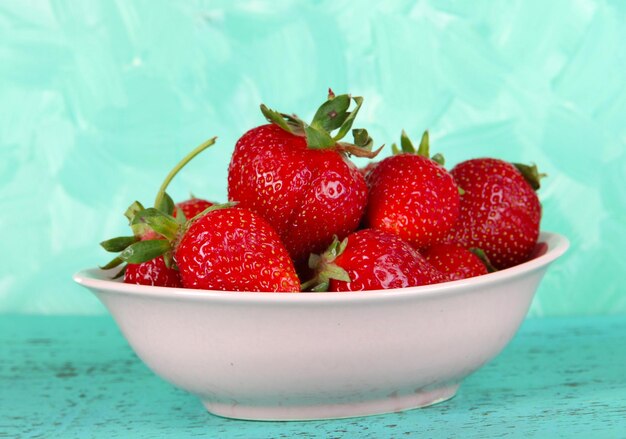 Strawberries in plate on blue background