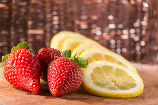 Strawberries and a sliced lemon refreshments of a summer afternoon