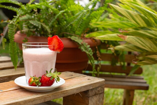 Strawberries smoothie with fresh fruit and milk in a glass with fruit decoration breakfast