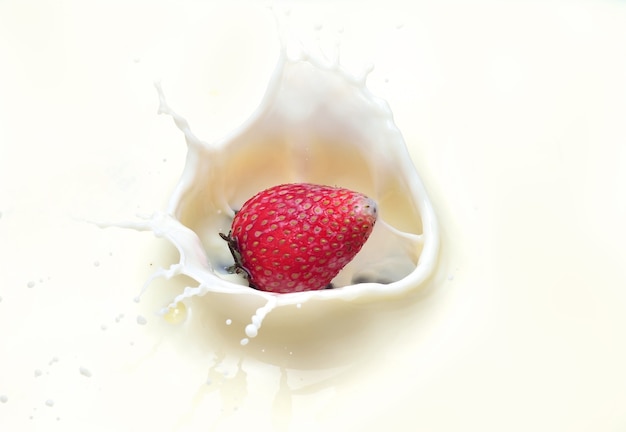 Strawberries splashing in to milk