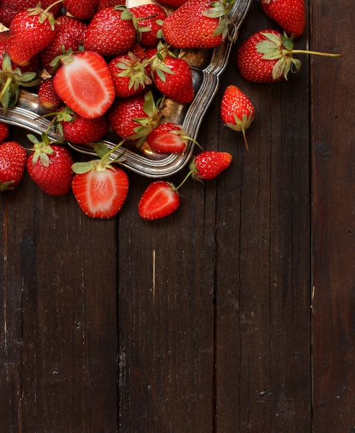 Strawberries in a tray on a dark wooden table