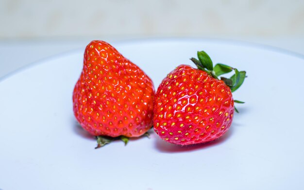 Strawberries in a white plate on a white table Selective focus