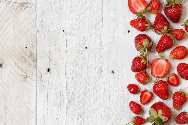 Strawberries on a white wooden table top view