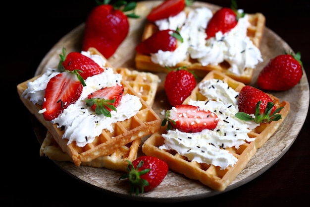 Strawberries with cream on Viennese waffles Summer dessert with strawberries