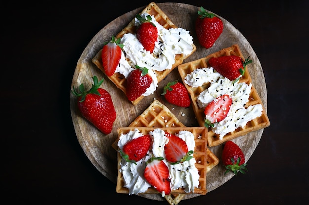 Strawberries with cream on Viennese waffles Summer dessert with strawberries