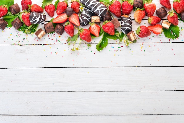 Strawberries with sweets On a white wooden background Top view Copy space