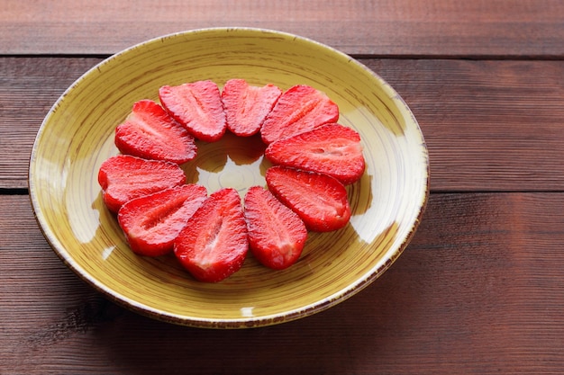 Strawberries on wooden boards Sliced strawberries on yellow plate Copy space