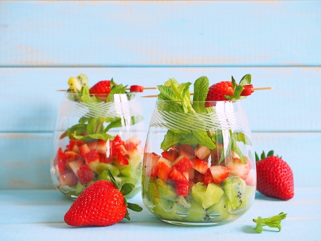 strawberris kiwi and mint leaves in glass