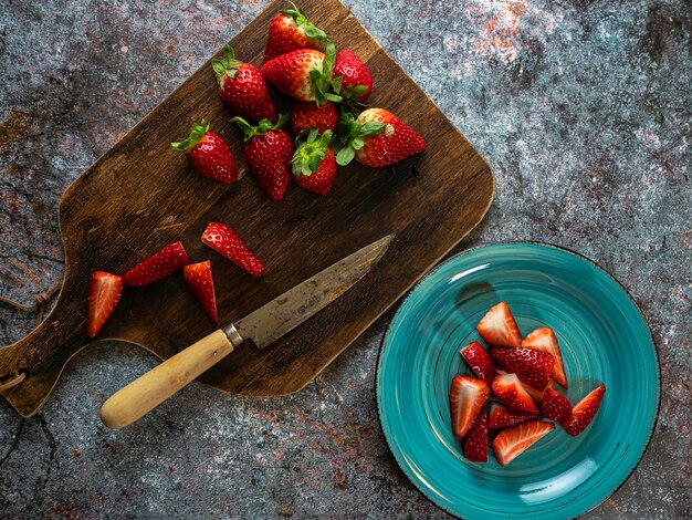 Strawberry background on a wooden board with a knife Copy space Top view Flat design