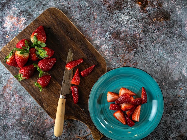 Strawberry background on a wooden board with a knife Copy space Top view Flat design