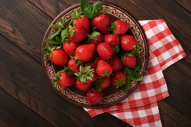 딸기 베리 나무 소박한 테이블 근접 촬영에 바구니에 세라믹 소박한 접시에 신선한 빨간 딸기 맛있는 육즙이 빨간 딸기 복사 공간이 있는 상위 뷰