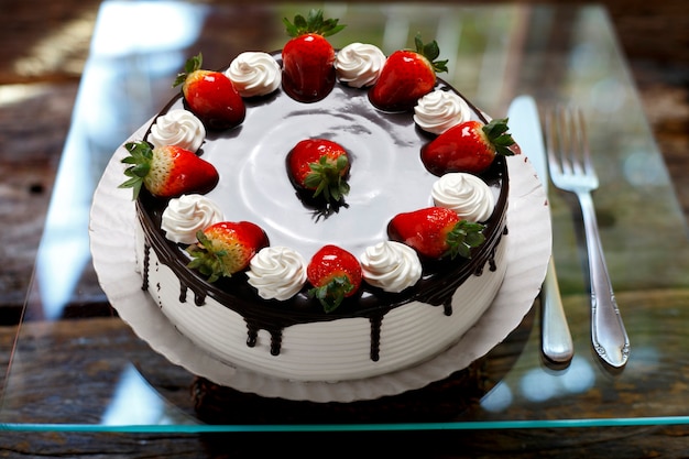 Strawberry birthday cake with whipped cream and chocolate