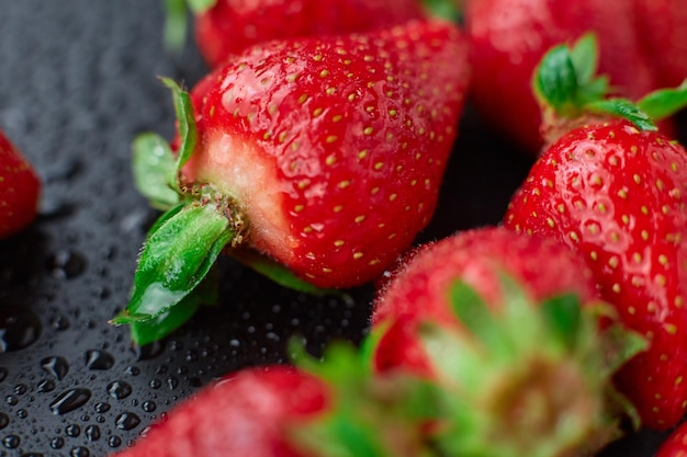 Strawberry on a black background with raindrops very fresh bright open diaphragm attractive advertis