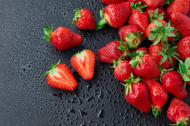 Strawberry on a black background with raindrops very fresh bright open diaphragm attractive advertis